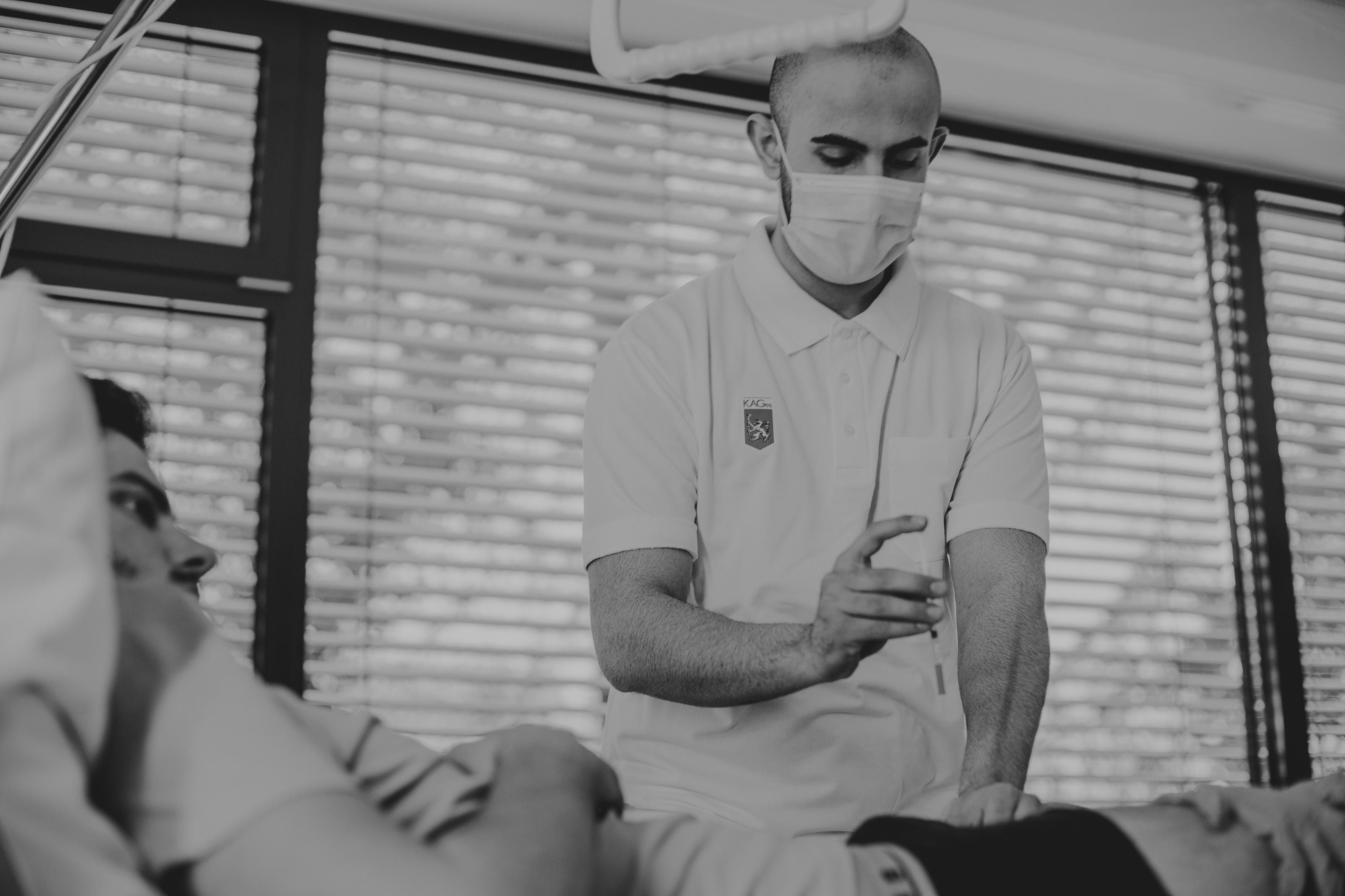 Bild einer Person die medizinische Tätigkeiten als Pflegefachassistenz an einem Patienten durchführt.